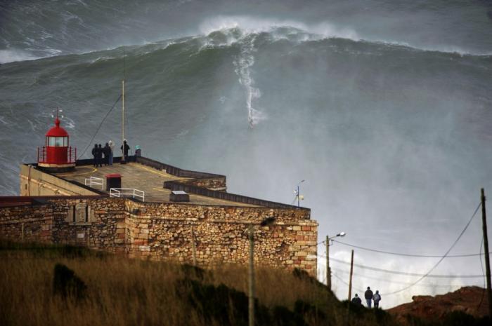 Серфингист Гаррет Макнамара покоряет волну высотой в 10-этажное здание, Португалия.
