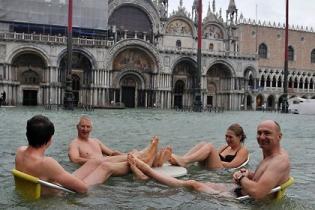 Туристы купаются в центре Венеции во время наводнения